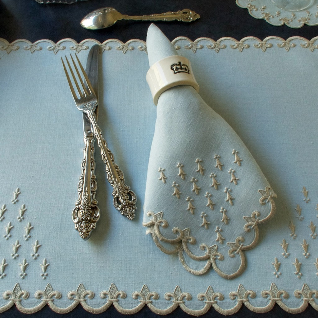 A placemat and napkin in Marghab's Old France pattern in blue, hand embroidered in Madeira