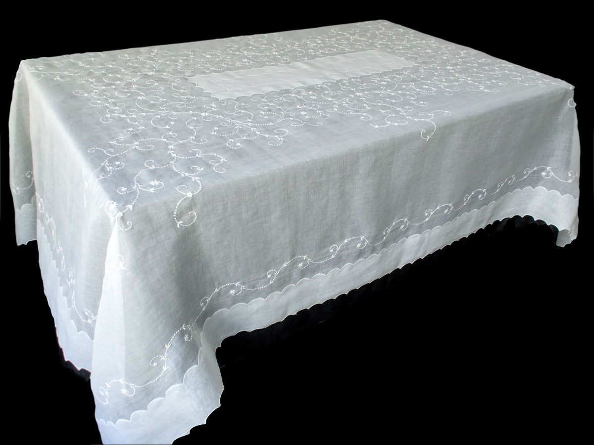 Vintage Marghab organdy tablecloth draped on table, hand embroidered in Madeira