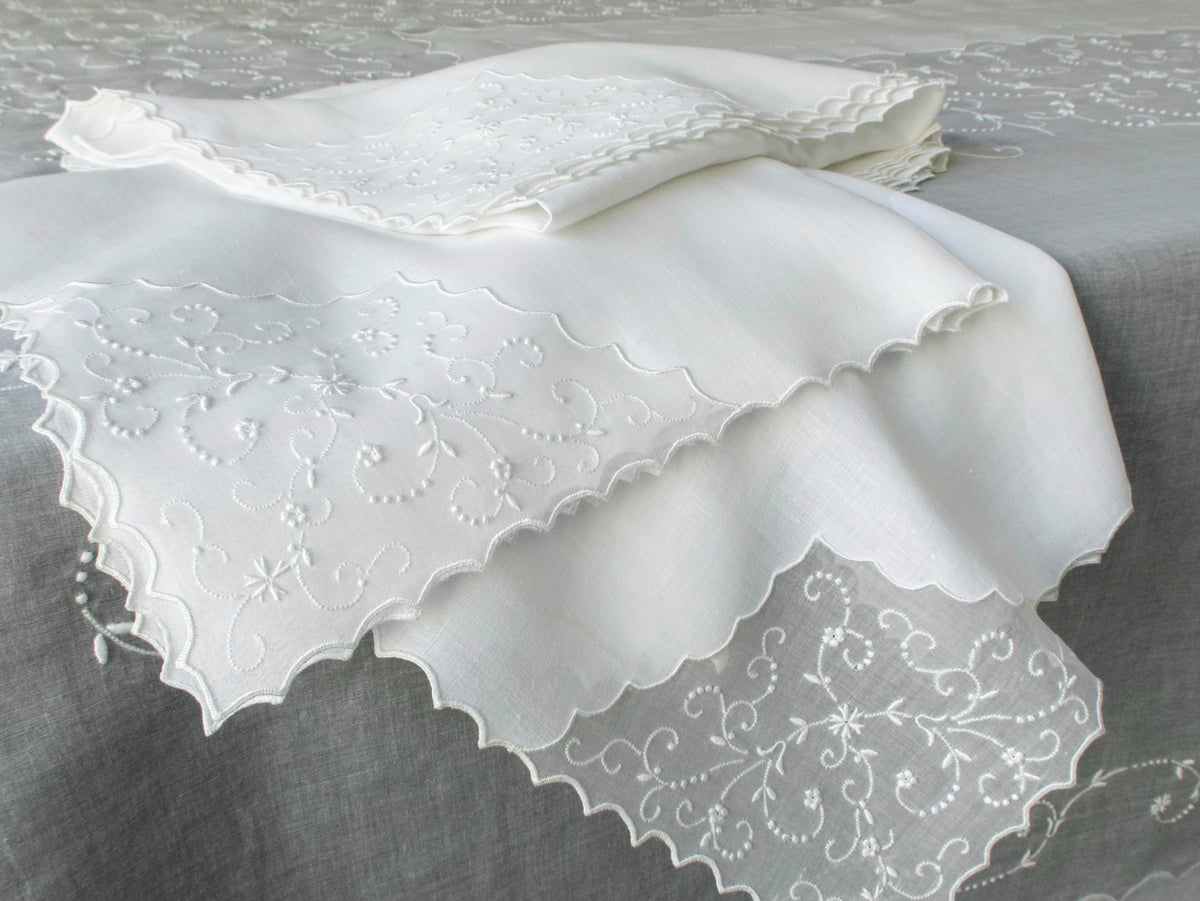 Close-up of vintage Marghab white embroidered linen napkins draped over a sheer organdy tablecloth, hand embroidered in Madeira