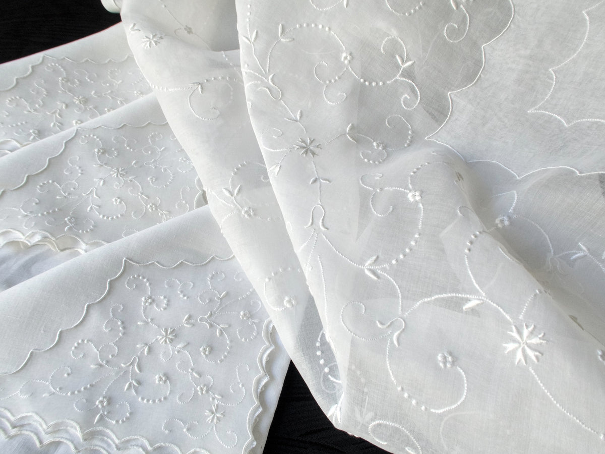 Close-up of vintage Marghab white embroidery on sheer organdy tablecloth, hand embroidered in Madeira