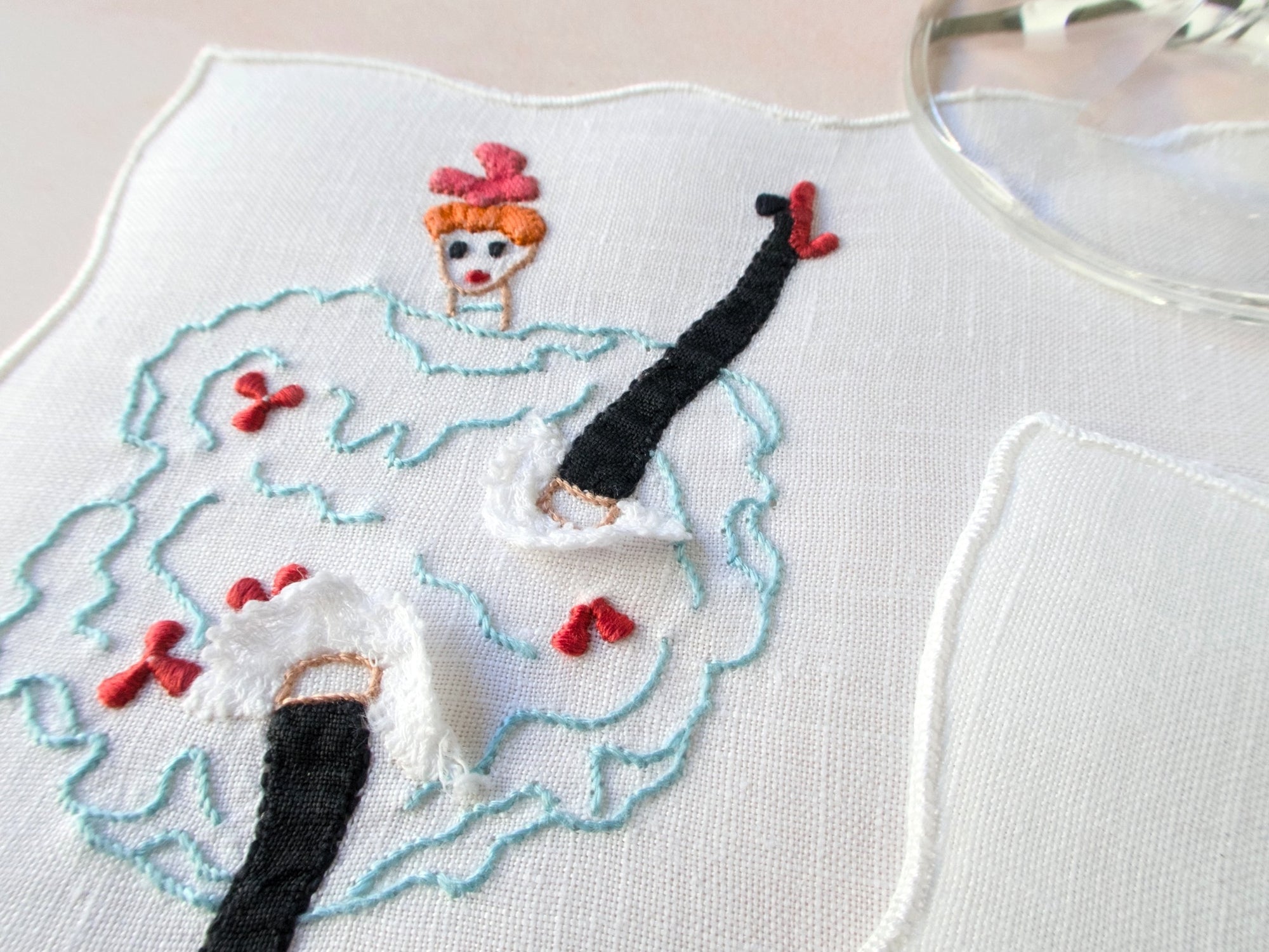 Vintage Madeira cocktail napkin with embroidered can-can dancer, frilly knickers, and applied lace.