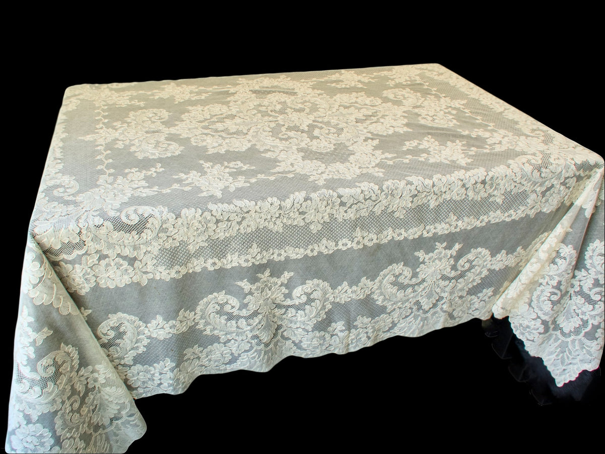 Vintage French Alençon lace tablecloth with scrolling floral border on black background