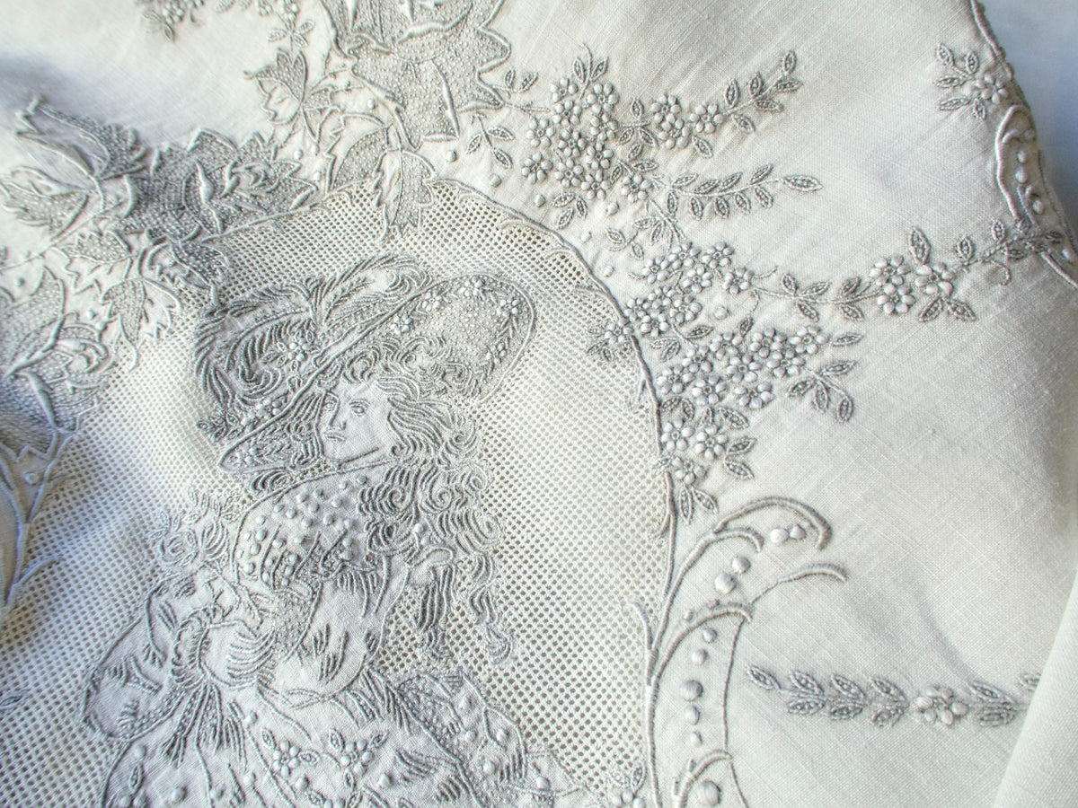 Angled view of vintage Swiss Appenzell tablecloth highlighting figural embroidery