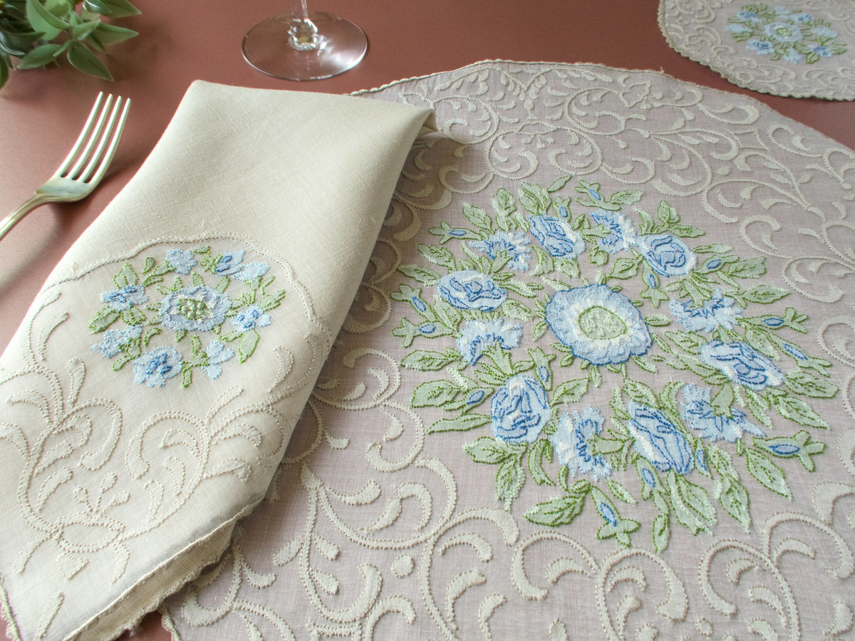 Vintage Madeira shadow work placemat set, round organdy placemat with blue flower embroidery and silverware on terracotta background