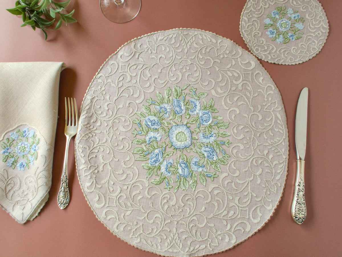 Vintage Madeira shadow work placemat set, round organdy placemat with blue flower embroidery and silverware on terracotta background