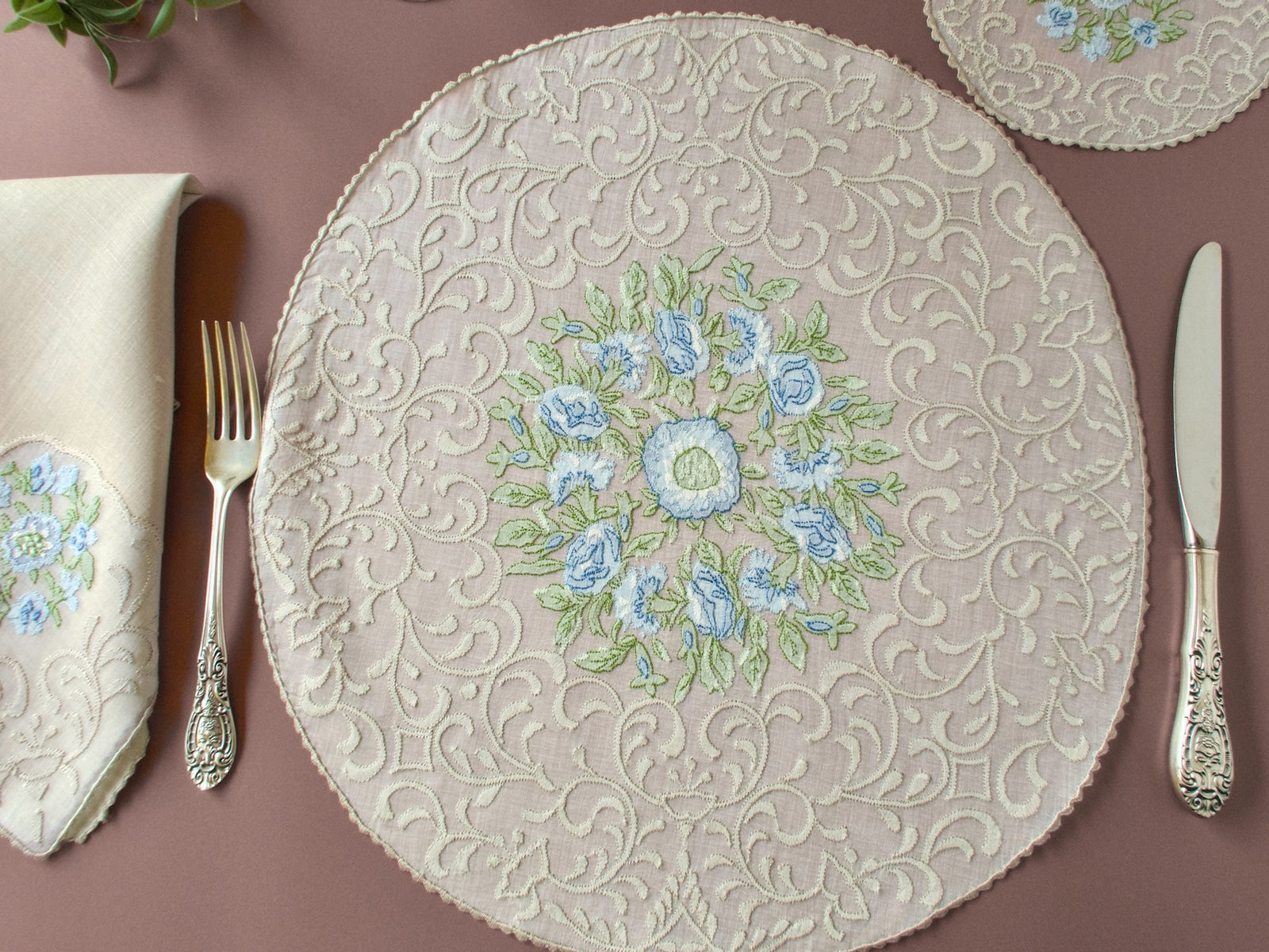 Vintage Madeira shadow work placemat set, round organdy placemat with blue flower embroidery and silverware on terracotta background