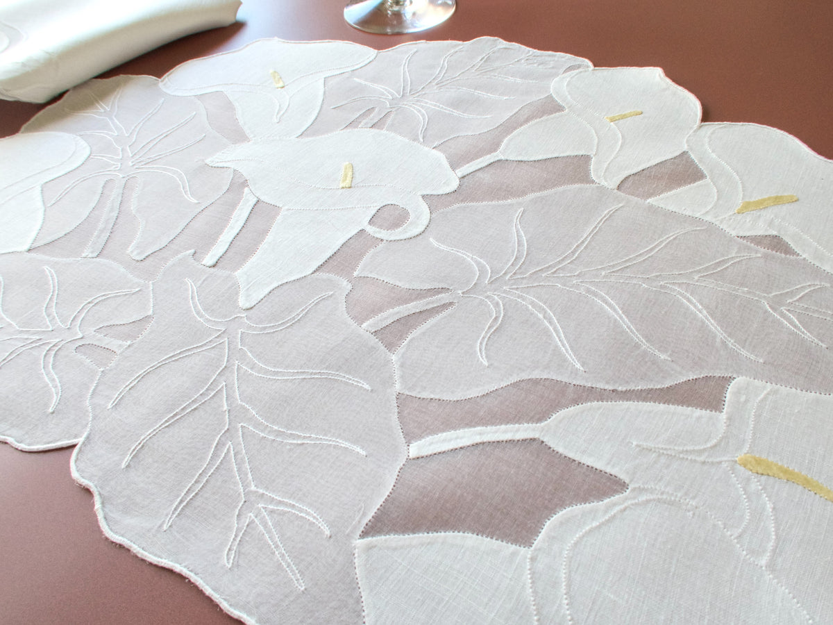 Close up of Madeira linen appliqué calla lily placemat, opaque linen petals on sheer organdy ground, pale yellow stamens