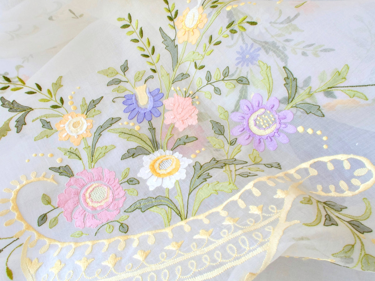 Detail of shadow work floral embroidery on sheer organdy tablecloth