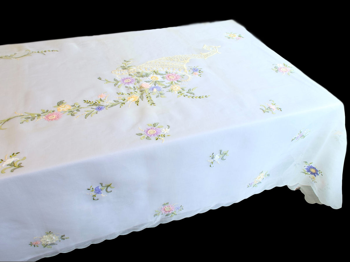Angled view of embroidered organdy tablecloth with cornucopia motif