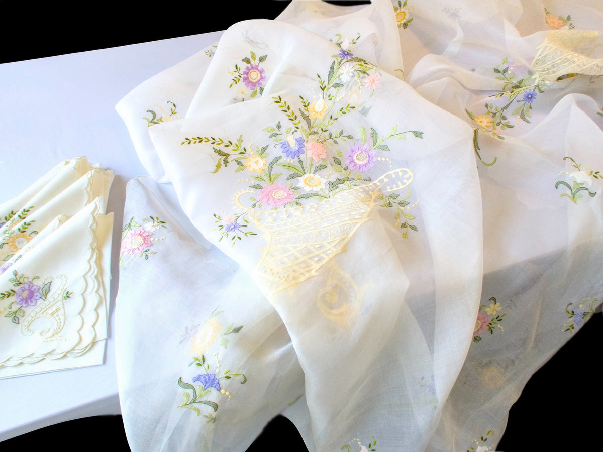 Angled view of draped embroidered organdy tablecloth with cornucopia motif