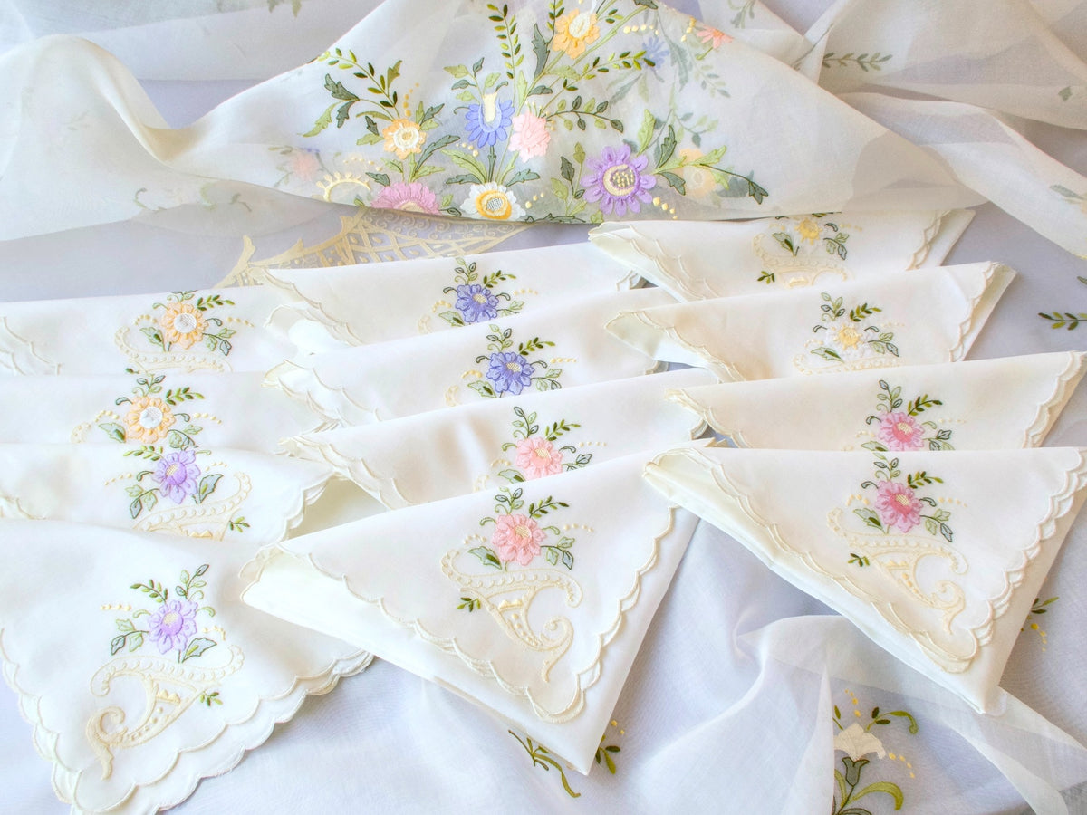 Set of twelve scalloped vintage embroidered napkins arranged together