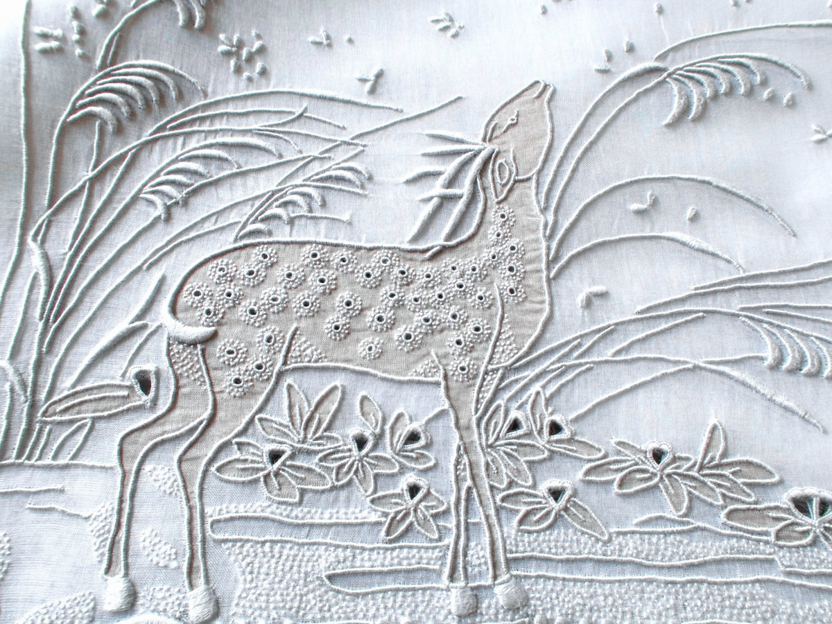 Closeup of vintage Marghab “Deer” orgndy placemat showing embroidered deer, grasses and landscape in gray 