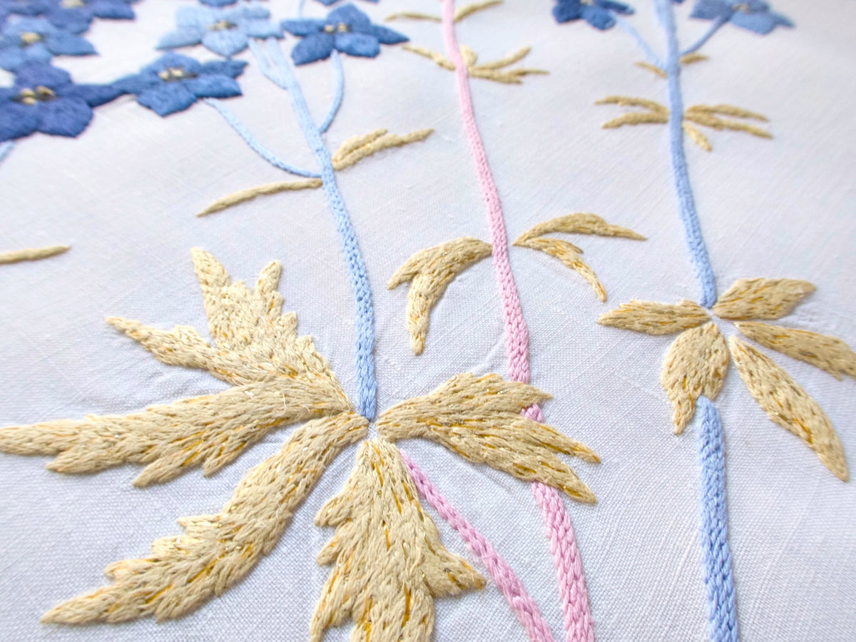 Close-up of vintage hand embroidered yellow embroidery with subtle gold thread on French tablecloth
