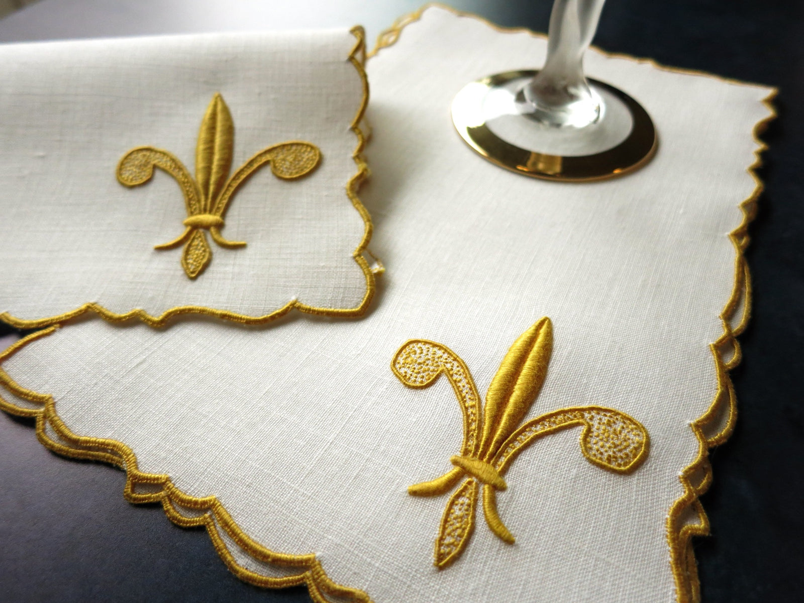Vintage linen cocktail napkins with raised gold fleur-de-lis embroidery and scalloped edges, hand embroidered in Madeira.