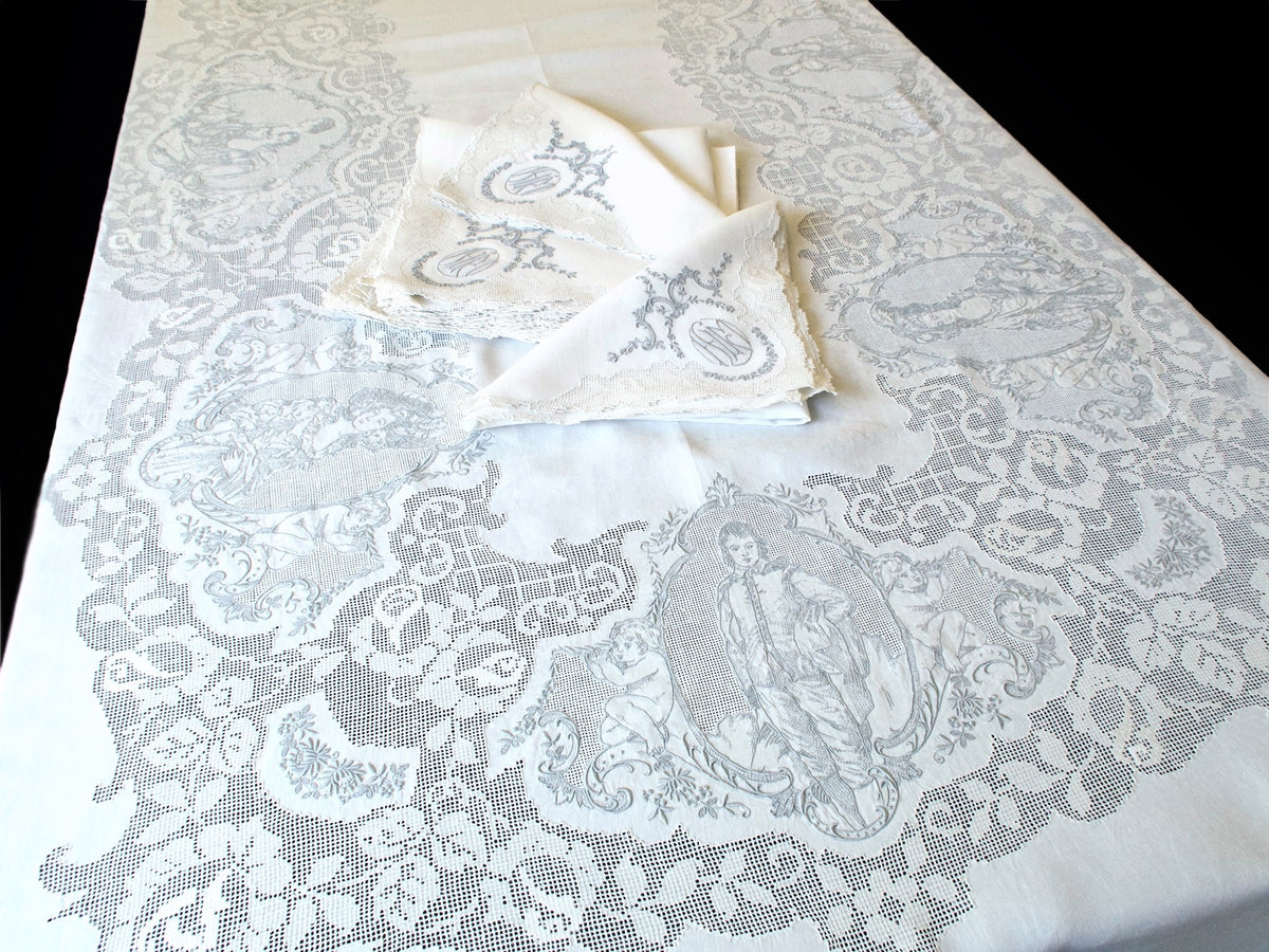 Gainsborough Appenzell linen tablecloth with monogrammed napkins, full view showing portrait panels and filet lace border