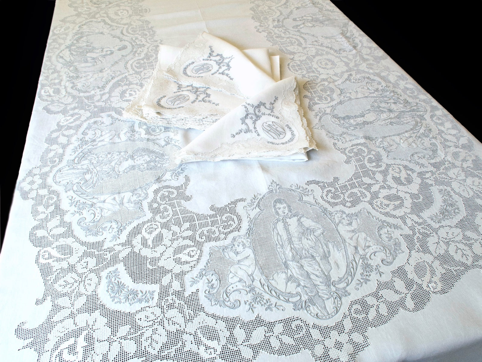 Gainsborough Appenzell linen tablecloth with monogrammed napkins, full view showing portrait panels and filet lace border
