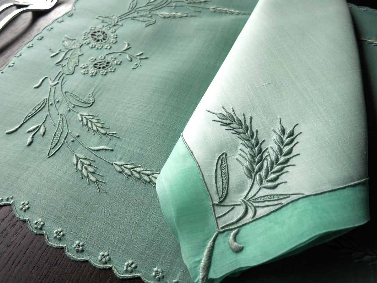 Close-up of green Marghab Wheat embroidered linen napkin, Madeira handwork detail.