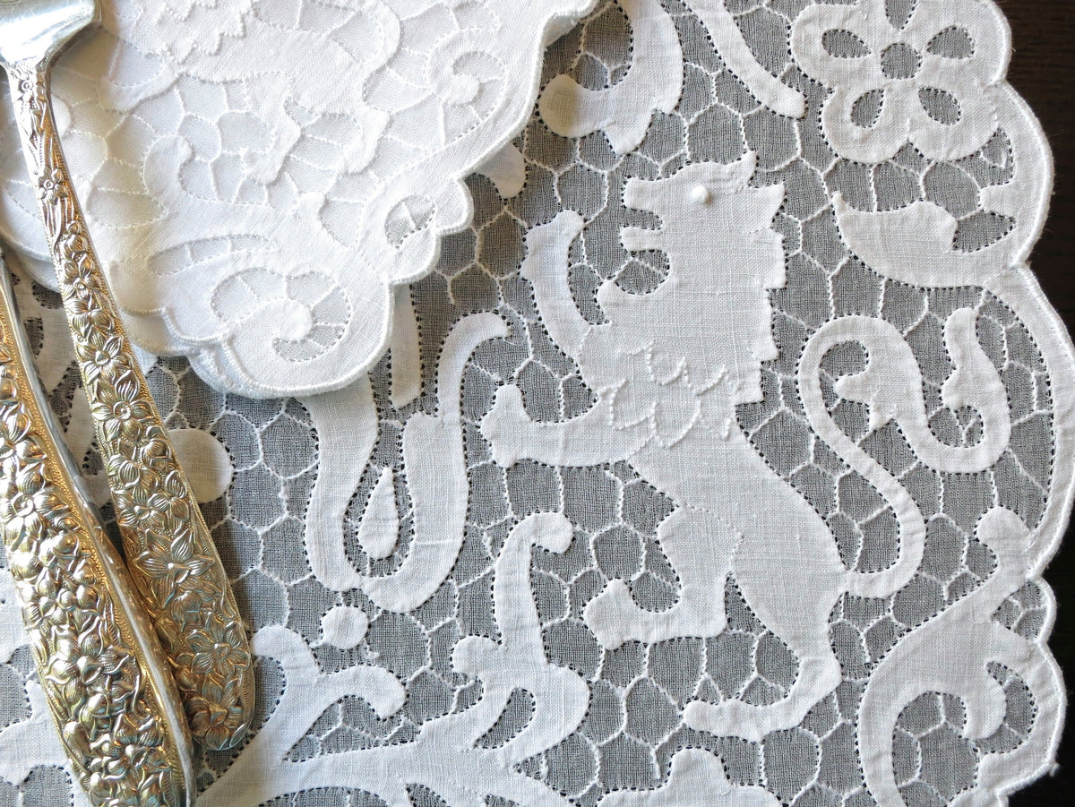Vintage Madeira linen placemat and napkin set featuring heraldic lion embroidery on a delicate honeycomb background.