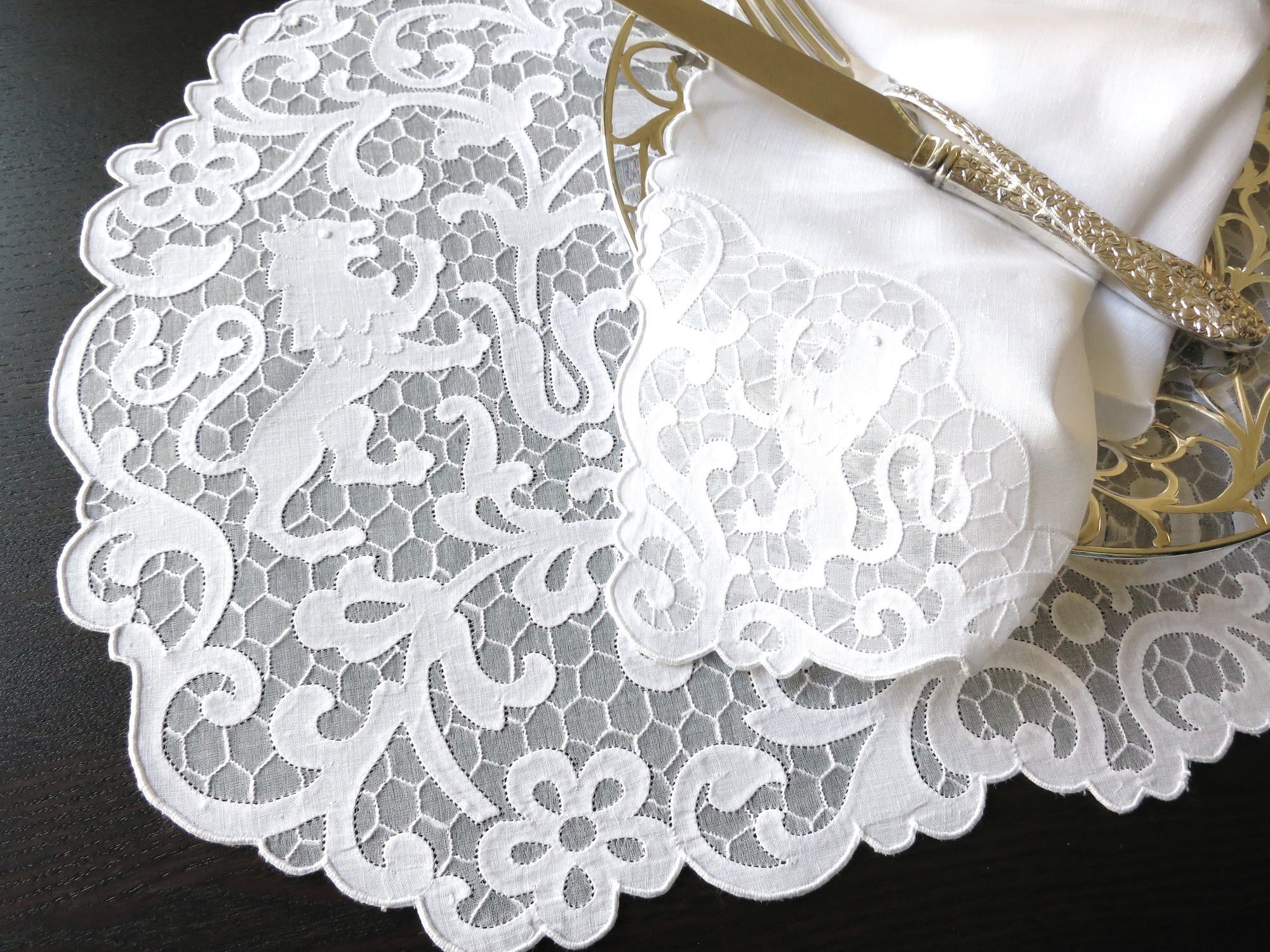 Vintage Madeira linen placemat and napkin set featuring heraldic lion embroidery on a delicate honeycomb background.