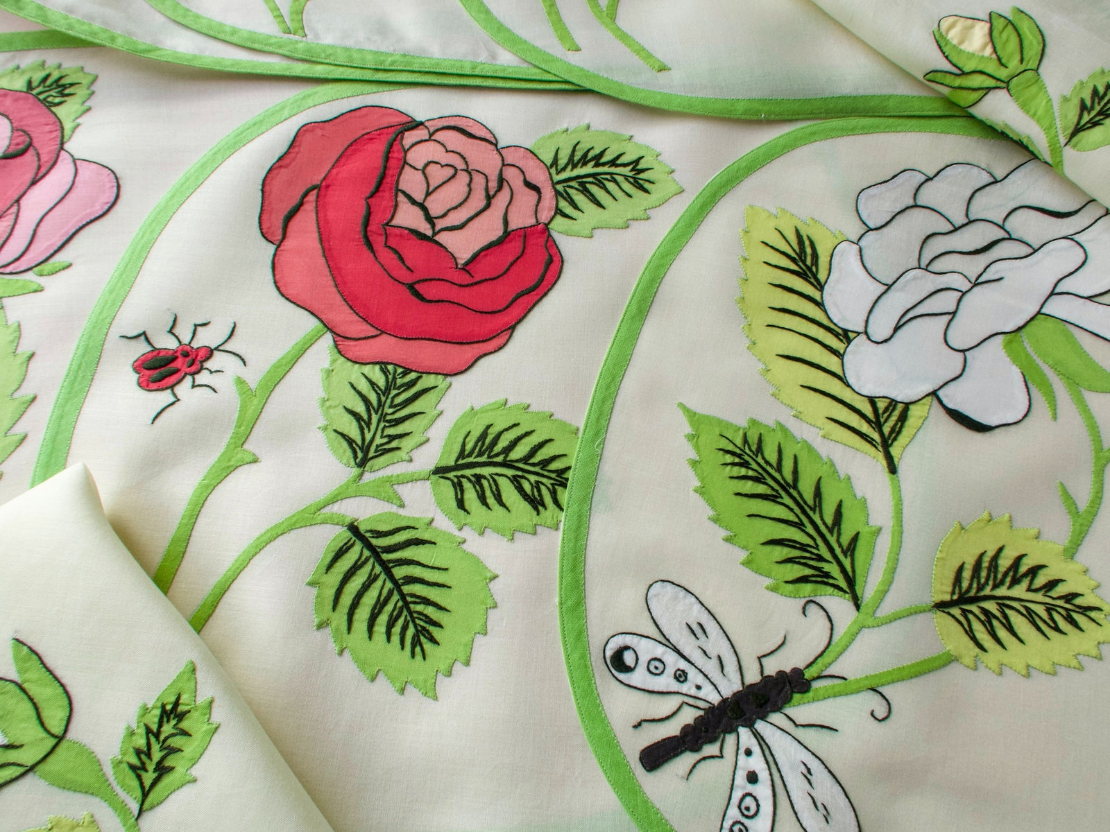 Vintage Italian appliqué placemat set showing roses in pink, yellow, and red with butterfly and ladybug insects on semi-sheer linen