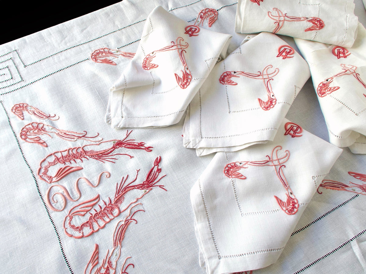 Antique French linen napkins with langoustine and monogram embroidery, folded and stacked