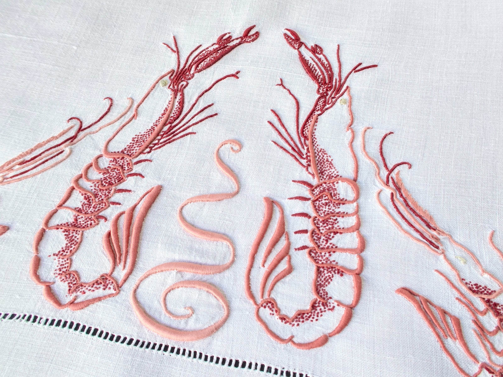 Detail of langoustine embroidery on antique French linen, showing three-dimensional stitchwork