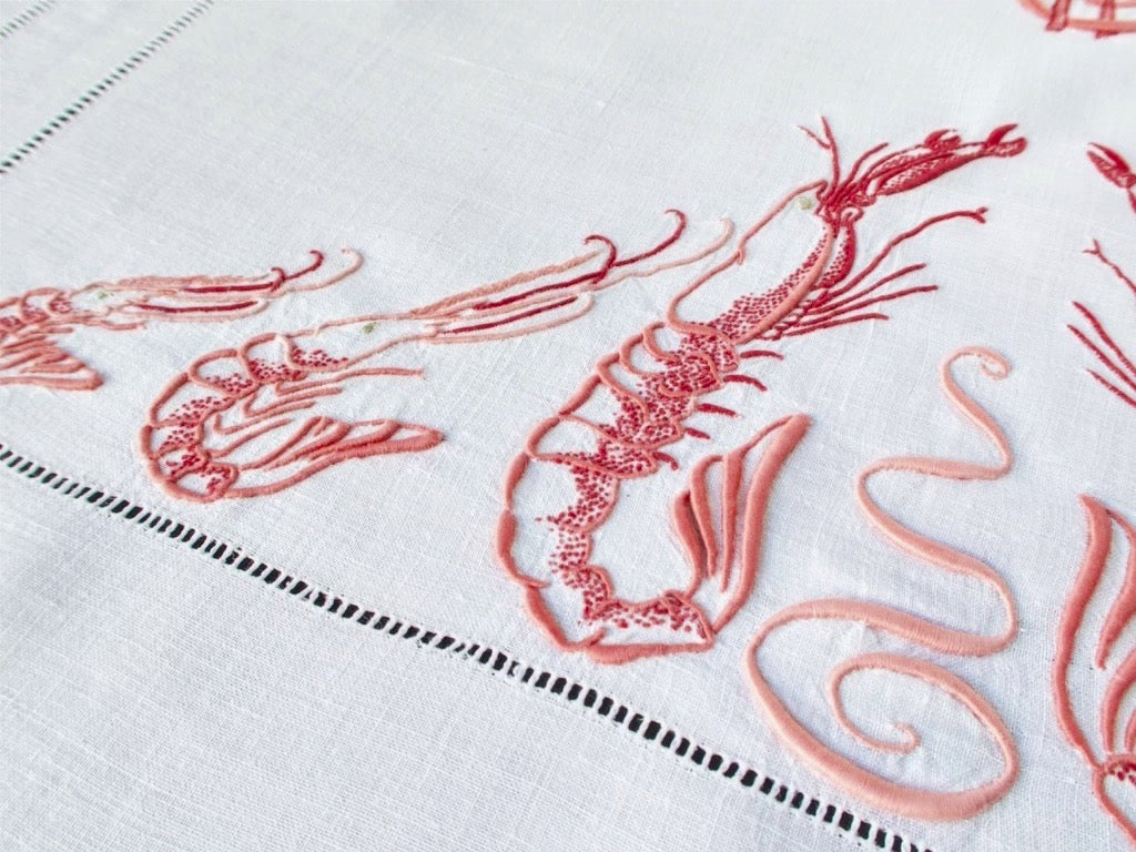 Hand embroidered langoustine and shrimp detail on antique French linen tablecloth