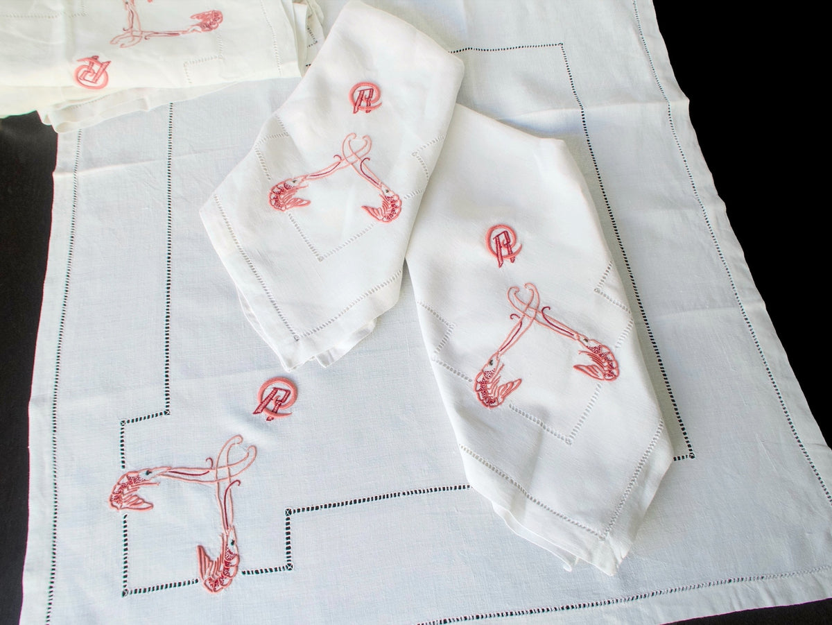 Antique French linen napkins unfolded showing full embroidery layout with hemstitch border