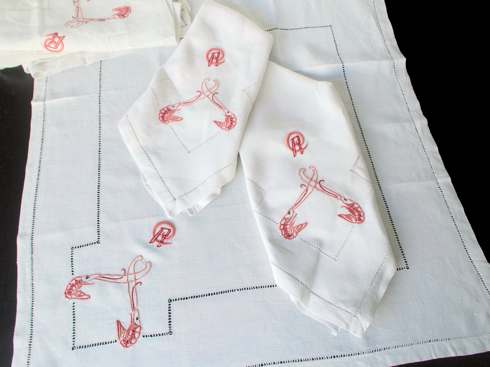 Antique French linen napkins unfolded showing full embroidery layout with hemstitch border