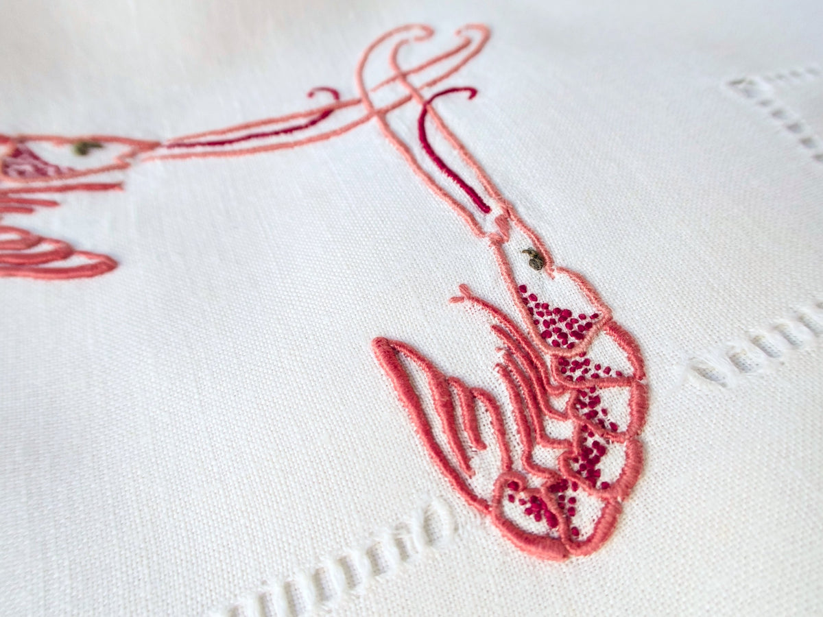 Detail of single langoustine embroidery on antique French linen, showing three-dimensional stitchwork