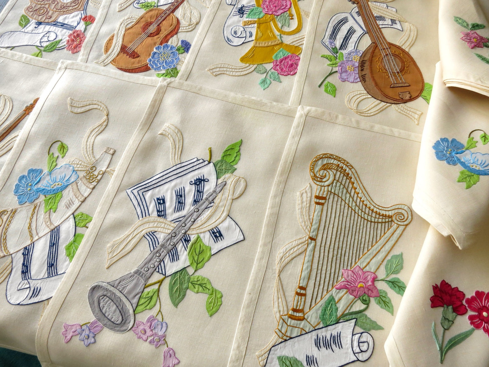Vintage Italian embroidered placemats with musical instruments and flowers, full 24-piece set for 12.