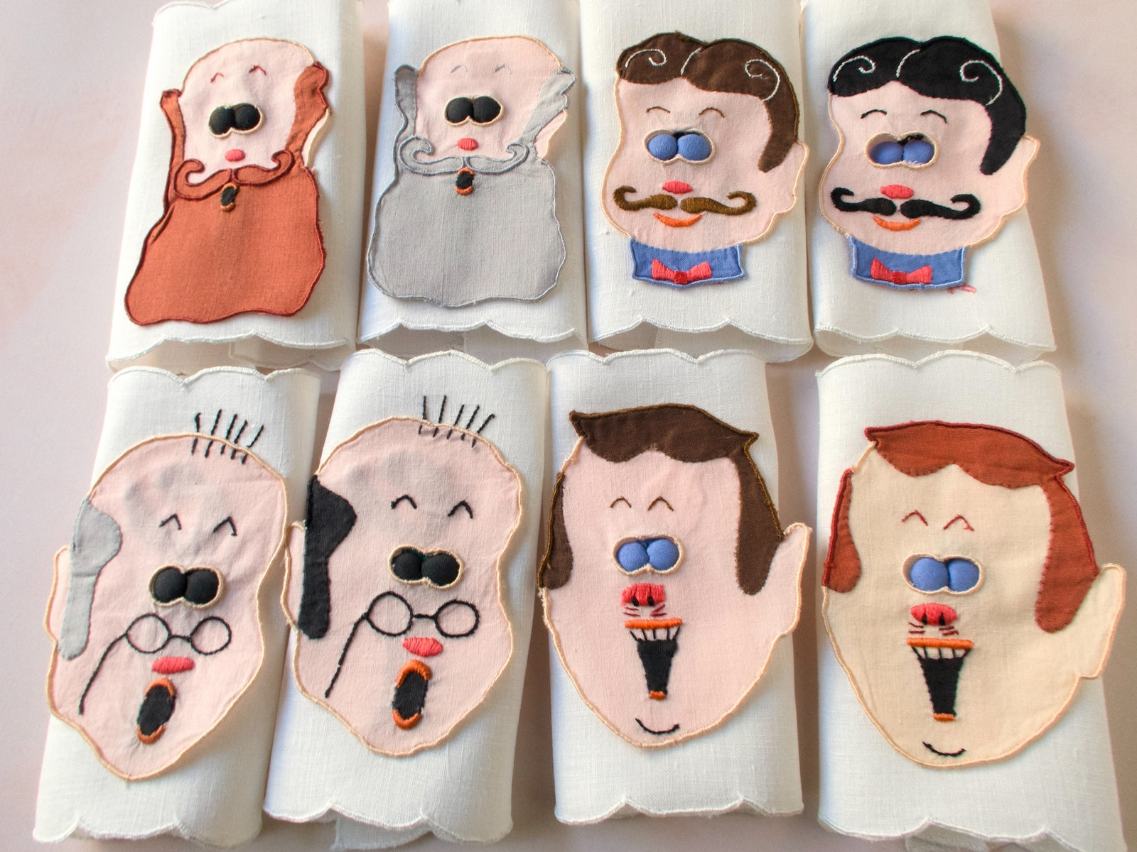 Vintage Madeira peek-a-boo cocktail napkins featuring embroidered men’s faces with blue padded ‘eyes’ that lift to reveal playful pin-up figures underneath. 
