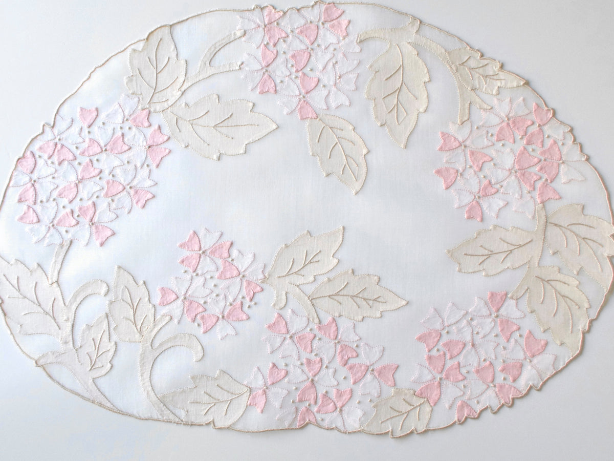 Vintage Madeira pink viburnum organdy round placemat showing full appliqué design with scalloped edge shaped by floral motif.