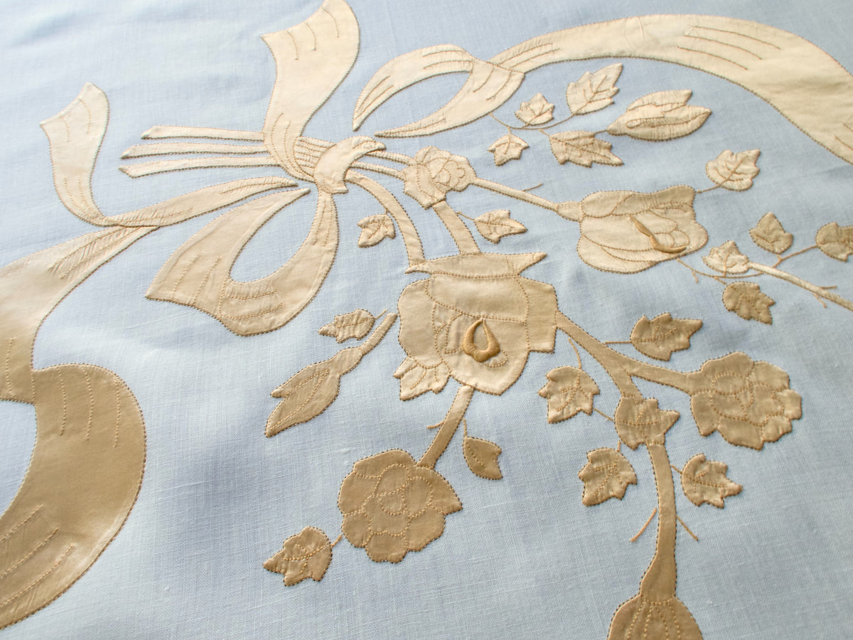 Detail of flowing satin ribbon embroidery on vintage Madeira tablecloth