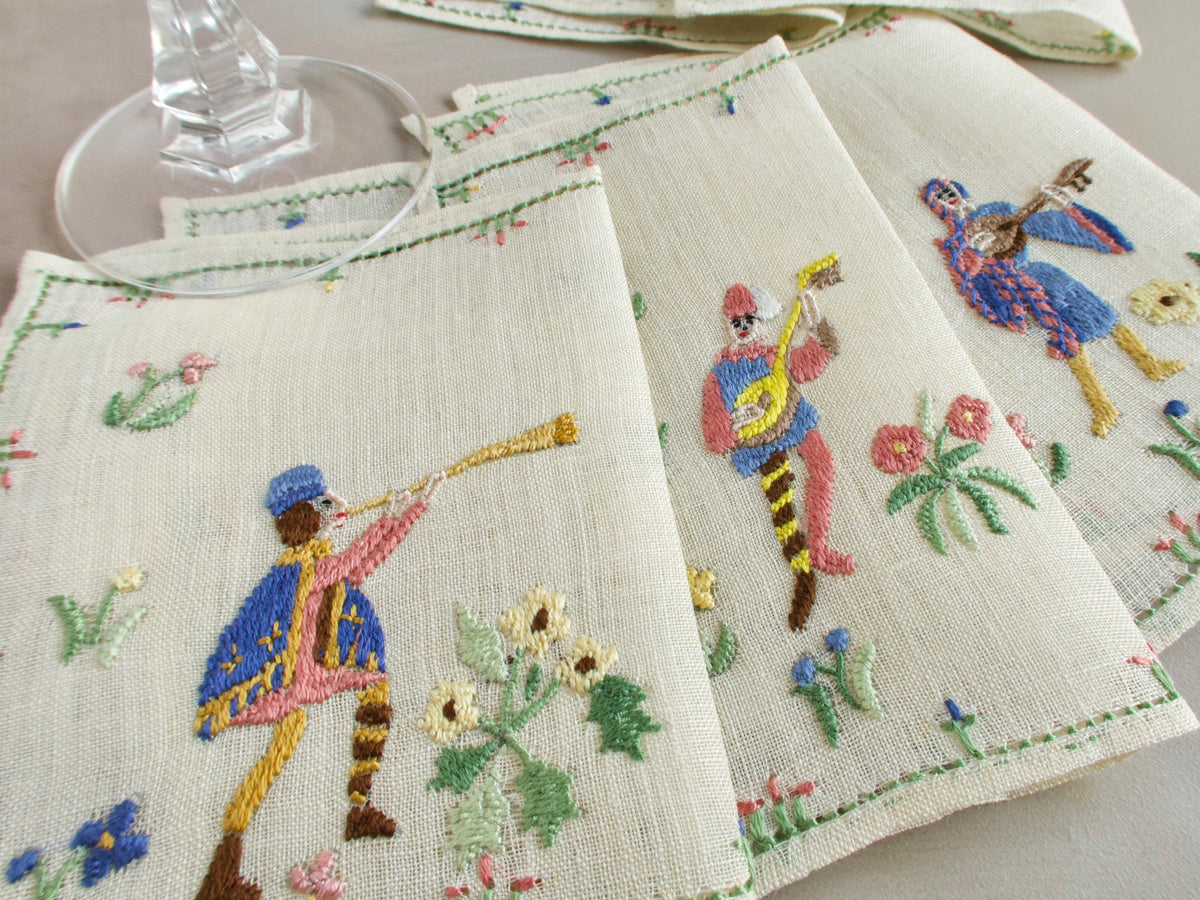 Rapisardi musician napkins showing a trumpeter and mandolin player with detailed floral embroidery.