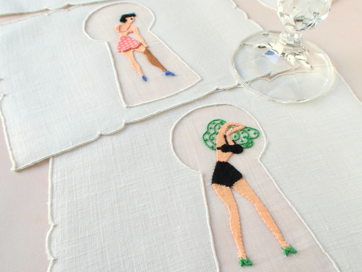 Detail of keyhole embroidery showing woman pulling off her green dress, vintage Madeira linen cocktail napkin.