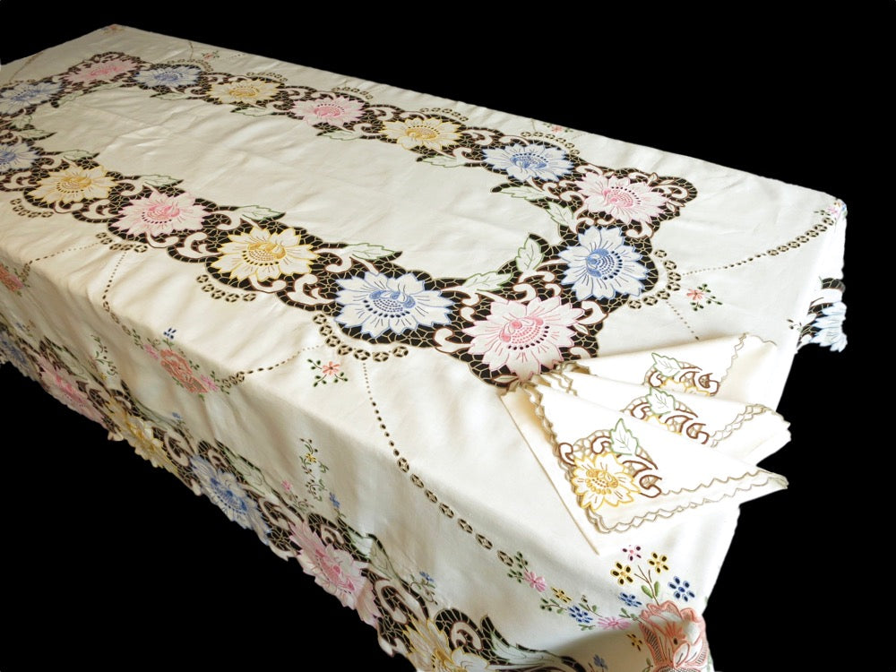 Vintage Madeira tablecloth and napkins hand embroidered with multicolored Richelieu florals on ivory linen, showing cheerful mid-century Madeira craftsmanship.