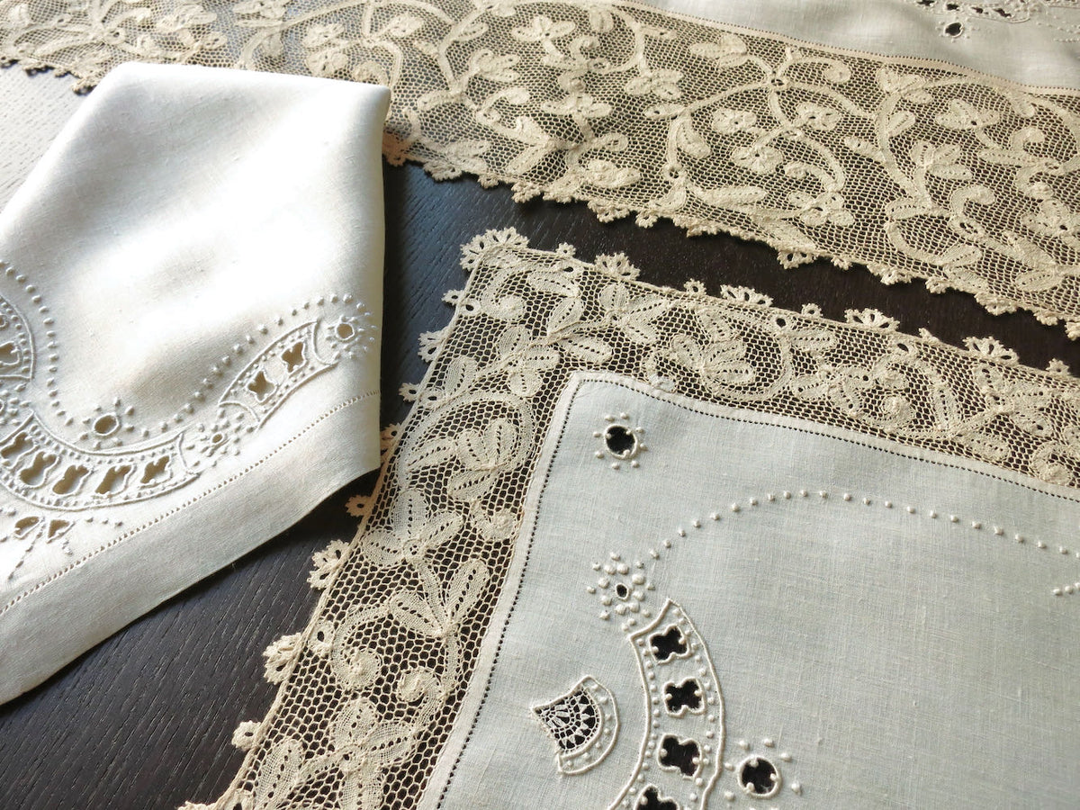 Details of a vintage Milanese lace and linen placemat set, with intricate embroidery and a white linen table runner.